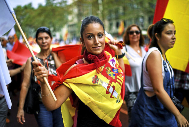Una mujer pasea ataviada con una bandera de España en la...