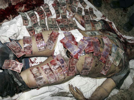 El cuerpo de 'El Barbas', lleno de billetes, yace cosido a balazos por los militares. | Ap