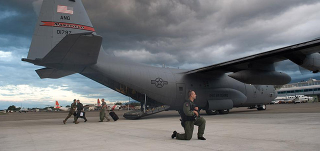 Un soldado aguardan mientras otros descargan, tras aterrizar en el aropuerto de Puerto Prncipe (Hait). | Afp