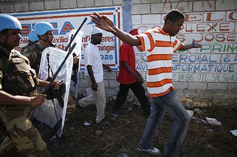 Los cascos azules dispersan a los haitianos que se acercan en busca de agua. | Reuters