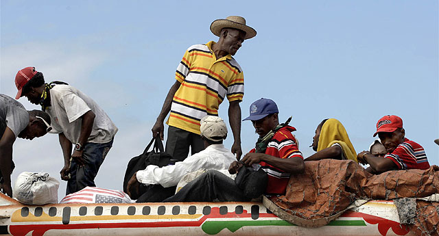 Los haitianos tratan de salir de Puerto Príncipe en un autobús. | Ap