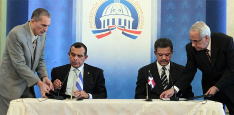 Pofirio Lobo (izq) y Leonel Fernndez (der) firman el acuerdo. |