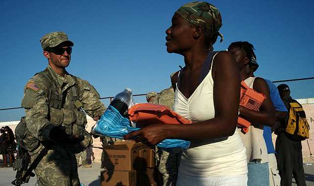 Un marine reparte víveres y agua entre las víctimas del terremoto de 'Cité Soleil', suburbio de Puerto Príncipe. | AFP