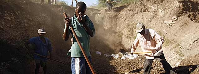 Varios haitianos entierran unos cadveres en una fosa comn cerca de Puerto Prncipe. | AFP