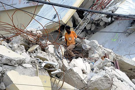 Un haitiano pasea entre los escombros de unas casas. | AFP