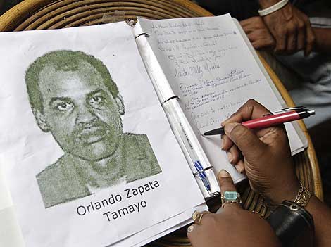 Una mujer firma en el libro de condolencias de Zapata Tamayo. | Reuters