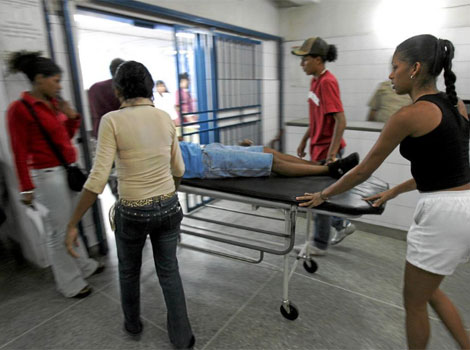 Traslado de un hombre atacado en un barrio de Venezuela, por ajuste de cuentas. | AFP