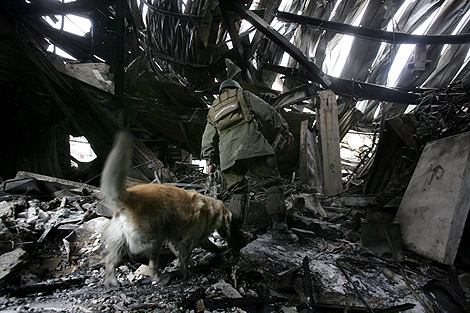 Un miembro de los equipos de rescate busca entre los escombros. | AFP