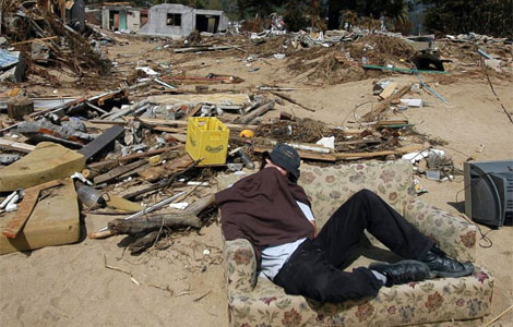 Un hombre descansa en un silln en medio del desastre que dej el terremoto. | Efe