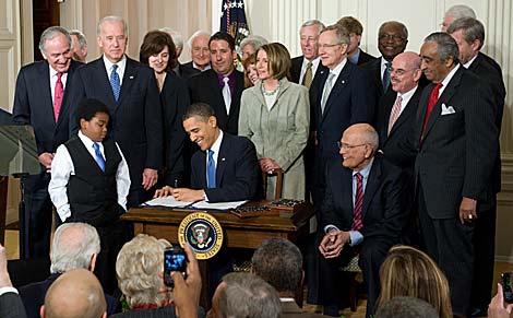 Un rodeado Barack Obama firmando la histrica ley. | AFP
