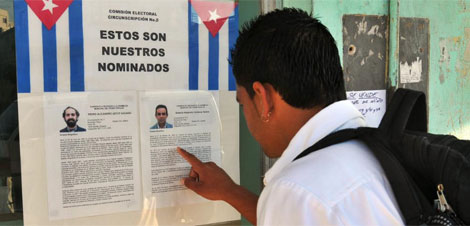 Un jven cubano consulta la biografia de dos candidatos. | Efe