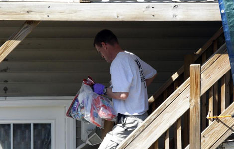 Un agente del FBI saca algunas cosas de la casa del sospechoso. | Reuters