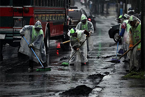 Trabajadores limpiando la ceniza del volcn durante el paso de la tormenta. | Reuters