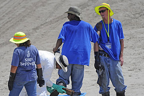 Trabajadores de BP son descontaminados al terminar sus labores de limpieza. | Efe
