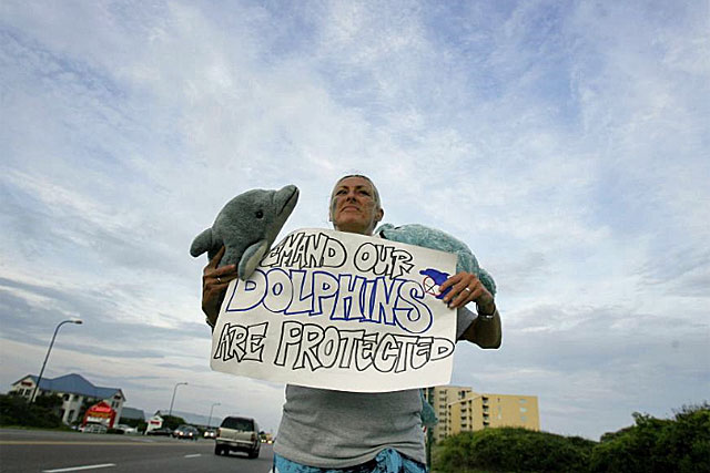 Una mujer reclama la proteccin de los delfines, cuya poblacin est amenazada junto a los cachalotes. | Reuters
