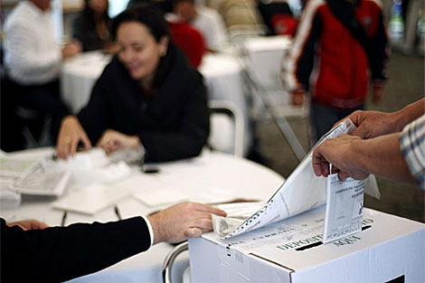 Un votante deposita el tarjetón en la urna electoral. | AFP
