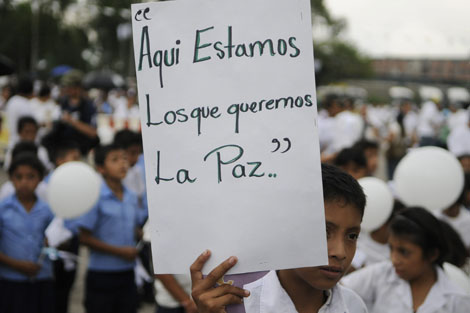 Un escolar salvadoreo porta una pancarta pidiendo paz. | Efe