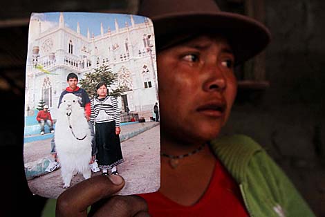 Angelita Lala, la esposa del ecuatoriano superviviente de la matanza, muestra la foto de ambos. | Efe