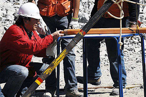 El ministro Golborne inspecciona uno de los tubos para enviar alimentos a los mineros. | AFP