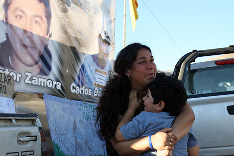 La mujer de Vctor Zamora, un minero, abraza a su hijo. | Afp