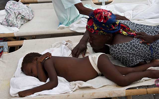 Una mujer cuida de su hija enferma de clera en un hospital de Hait. | Afp