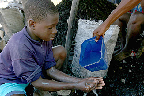 Un nio haitiano lavandose las manos. | AFP