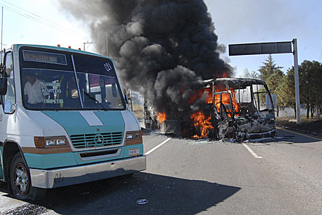 Uno de los vehculos incendiados en carreteras de Morelia. | AP