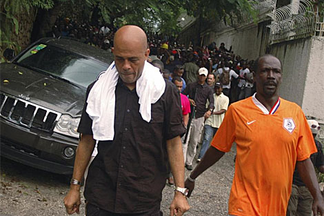 Michel Martelly sale de su casa mientras sus seguidores le gritan. | Reuters