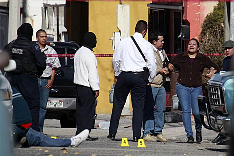 Dos hombres sujetan a una mujer que llora la muerte de un familiar en Ciudad Jurez. | AP