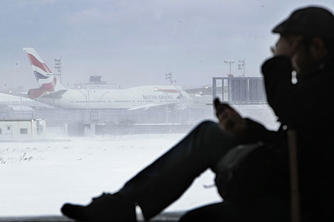 Un hombre habla por telfono mientras aterriza un avin en el aeropuerto JFK. | AP