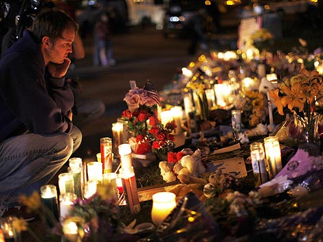 Un hombre mira el memorial levantado en honor a las vctimas de Arizona. | Reuters