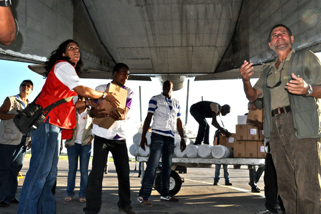 Miembros del Cruz Roja espaola y la Agencia de Cooperacin descargan un avin con ayuda de emergencia. | Rui Ferreira