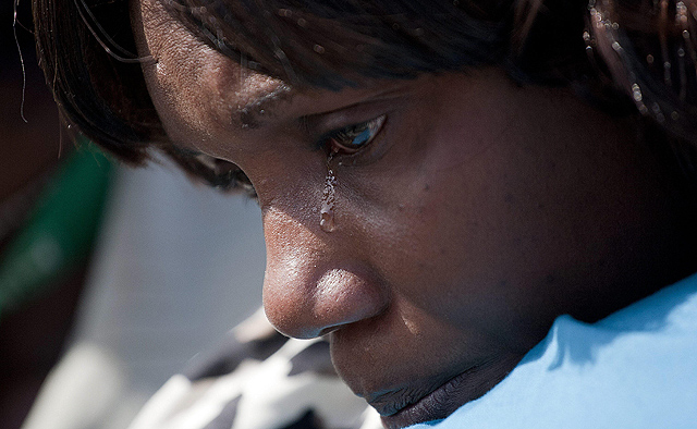 Una mujer llora frente a las fosas comunes de las víctimas del terremoto. I Efe