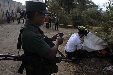 Un soldado guatemalteco toma una foto de los cuerpos calcinados. | Efe