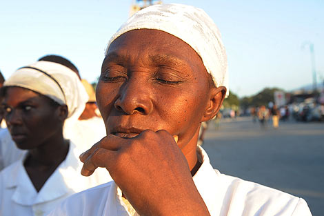 Una mujer guarda un minuto de silencio por las víctimas. | Afp