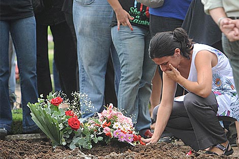Una mujer llora sobre la tumba de Wanda Taddei, quemada por su marido.