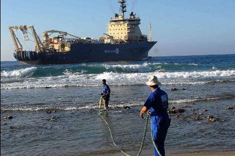 Obreros cubanos arrastran un cable submarino de fibra en Siboney, en Santiago de Cuba. | Efe