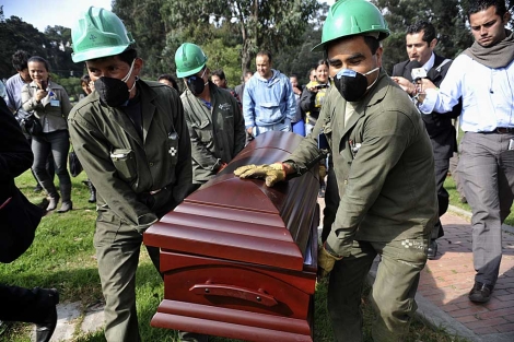 Trabajadores del cementerio Jardines del Apogeo trasladan el fretro. | AFP