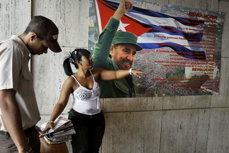 Una mujer gesticula frente a una proclama con la imagen de Castro, en La Habana. | AP