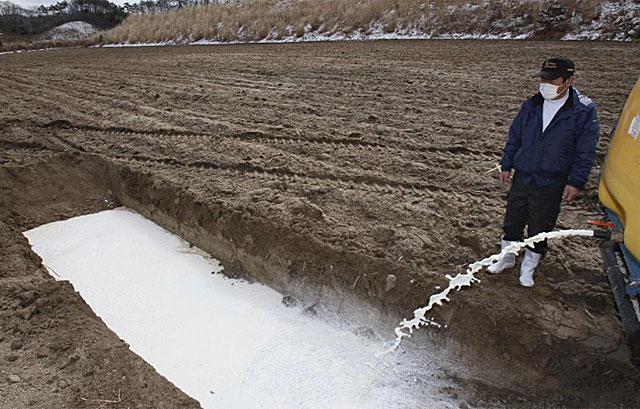 Un granjero vierte leche en una fosa en Fukushima, en el norte de Japn. | Reuters