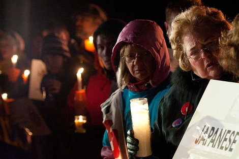 Manifestantes con velas y carteles en una vigilia por el 32 aniversario de Three Mile Island. | AFP