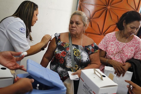 Una mujer recibe la vacuna contra la gripe A en Caracas. | Reuters