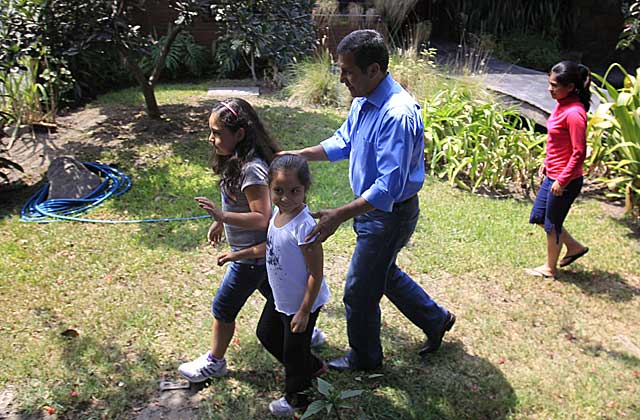 Humala camina con sus hijas por el jardn de la casa de su padre. / Reuters