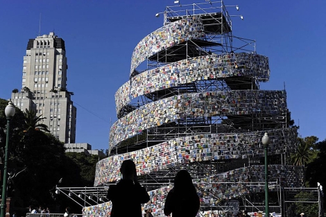 Dos personas observan la torre de libros en la plaza San Martín de Buenos Aires. | AFP