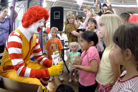 El payaso de McDonald's juega con unos niños en uno de sus restaurantes. | AP