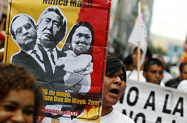 Un manifestante levanta una pacanrta con la imagen de Montesinos, Fujimori y su hija y candita, Keiko. | Reuters