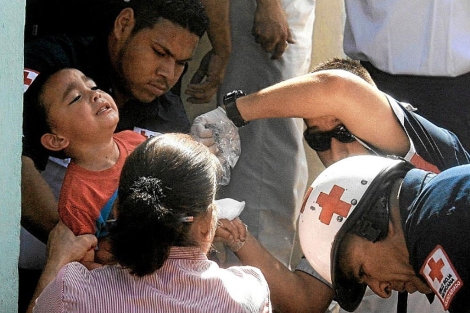 Socorristas de Cruz Roja evacuan a un nio de la guardera. | Efe