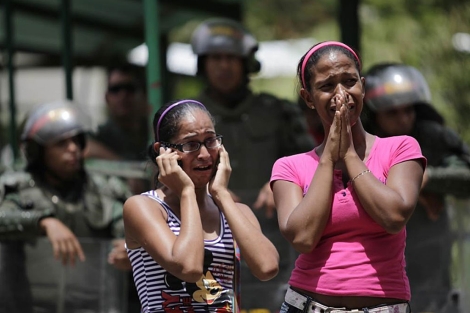 Dos mujeres esperan noticias de sus familiares, presos en el El Rodeo I, cerca de Caracas. | Ap