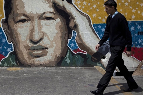 Un hombre camina por delante de un mural dedicado a Chvez en Caracas. | Reuters