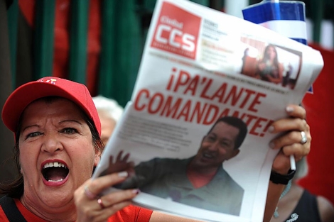 Una partidaria de Chvez muestra uno de los diarios de este viernes dedicados a Chvez. | AFP
